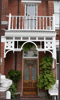 Edwardian house with elegantly carved wooded porch and balcony