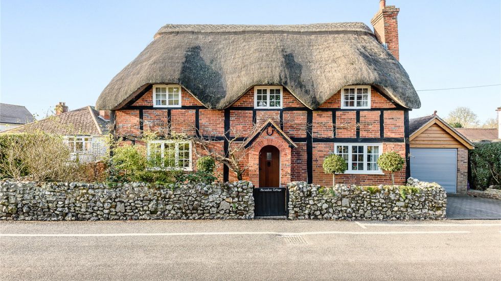 Three bay bricknogged timber-frame to the front with a thatched roof Elizabethan house